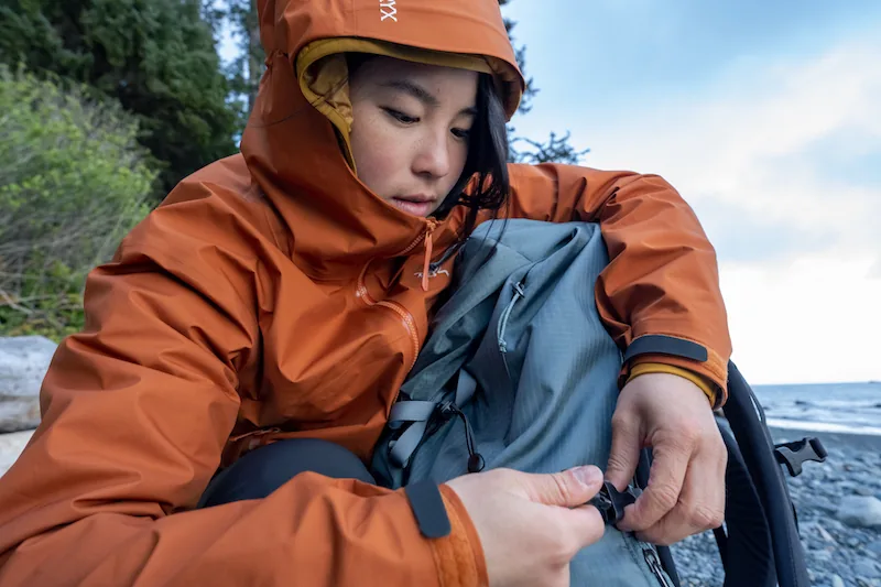 Hiker adjusting a backpack beside the coast